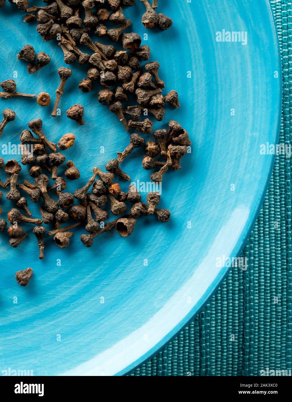 Cumulo di materie, essiccato cannella dei boccioli spice sulla piastra blu sfondo con il fuoco selettivo Foto Stock