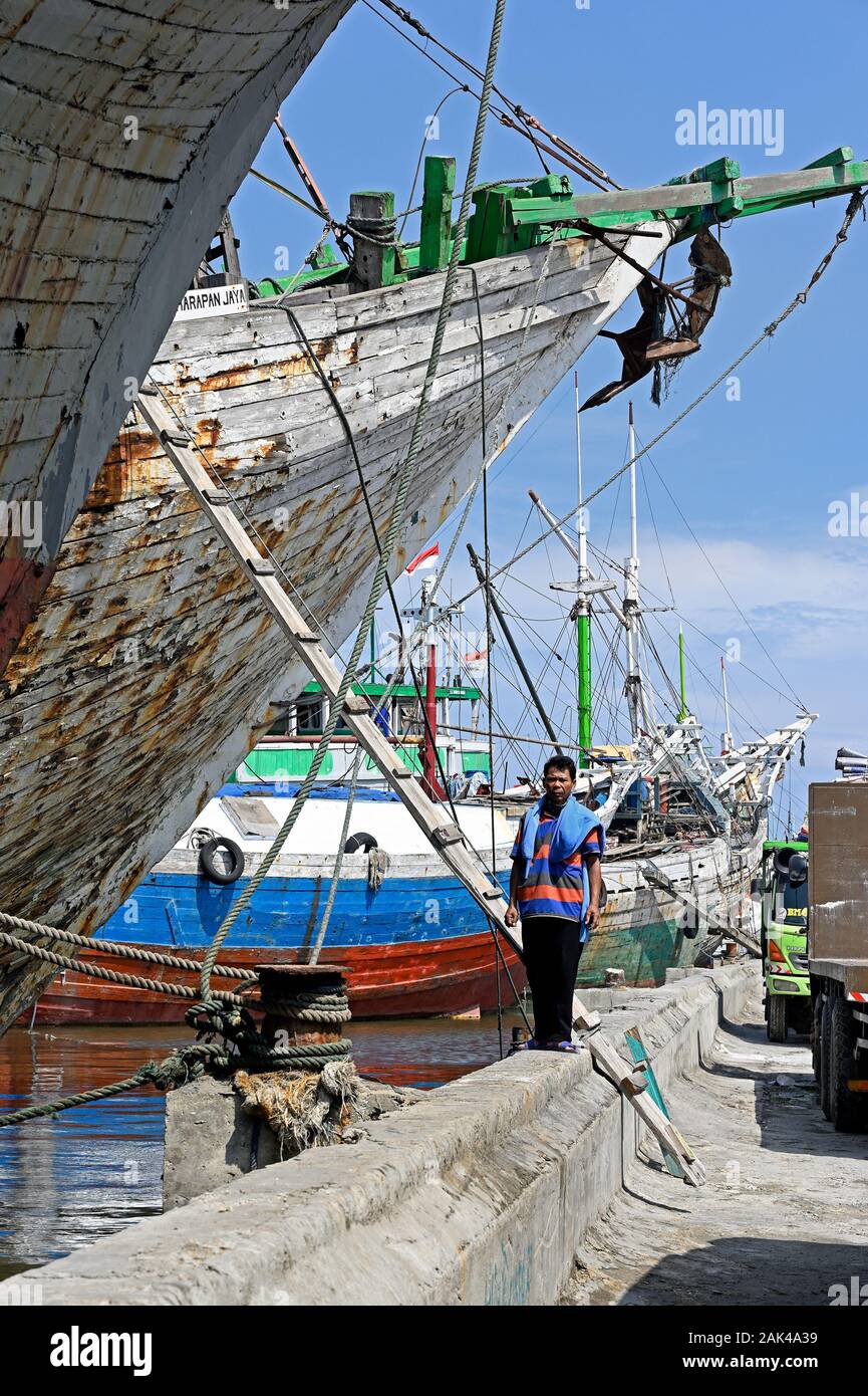 Jakarta, Indonesia - 2019.12.18: le operazioni di movimentazione del carico su e da legno pinisi prahu (kapal layar motor klm) a Sunda Kelapa port Foto Stock