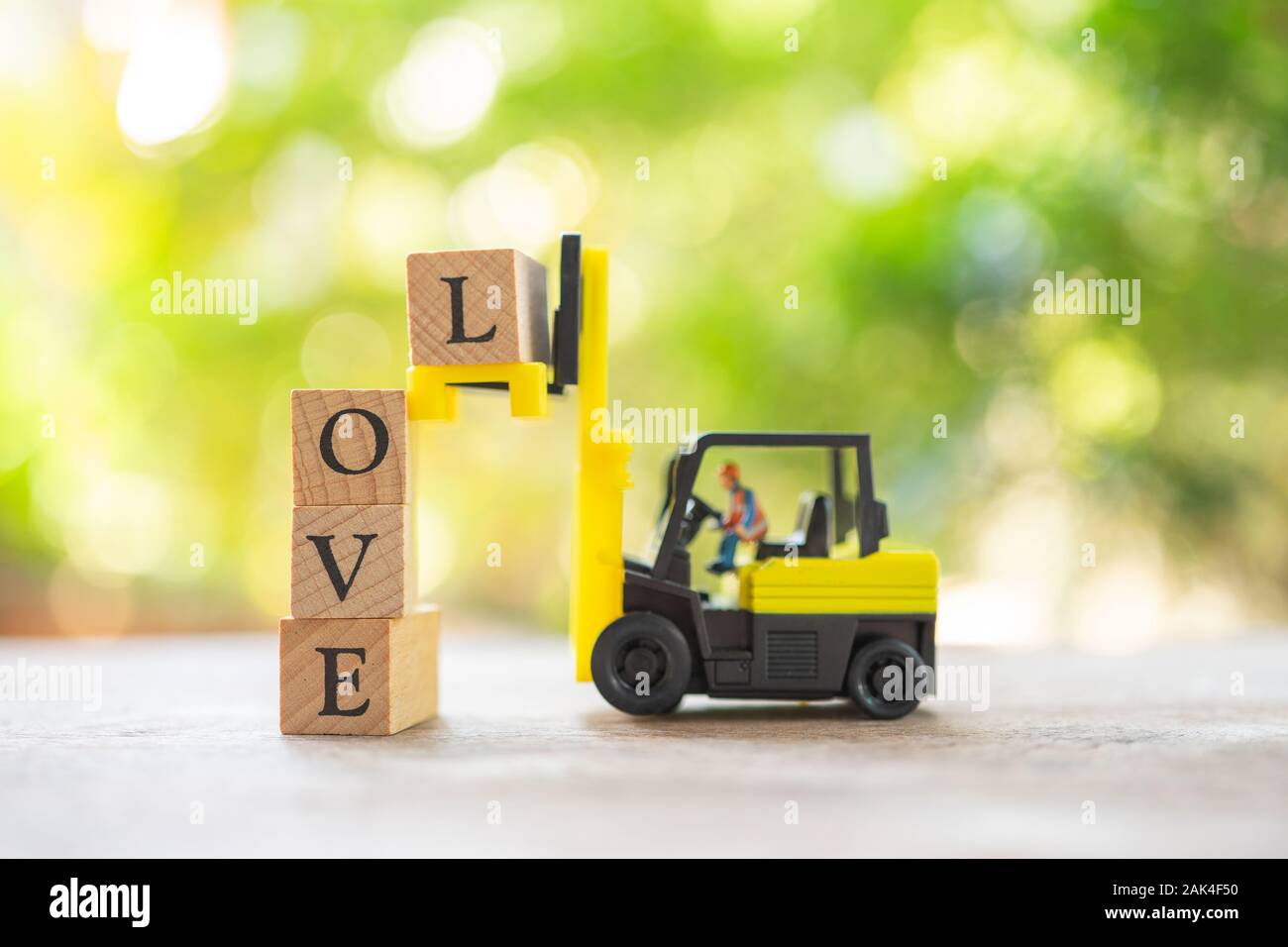 Persone in miniatura Costruzione lavoratore il legno con la parola AMORE. Giorno 14 incontra il giorno di San Valentino. utilizzando come sfondo il concetto di San Valentino con spazi di copia per voi Foto Stock