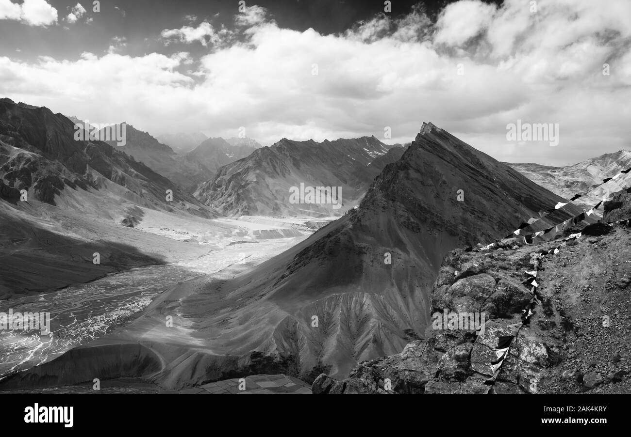 Spiti fiume si snoda attraverso la valle di Spiti fiancheggiata da alte vette dell'Himalaya e bandiere da preghiera buddista vicino a Kaza, Himachal Pradesh, India. Foto Stock