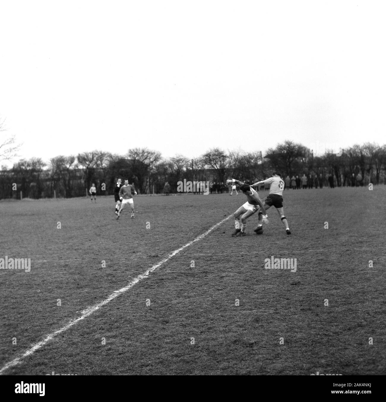 Anni sessanta, storico calciatori dilettanti giocando su un prato passo fangoso tipico dell'epoca, Inghilterra, Regno Unito. Foto Stock