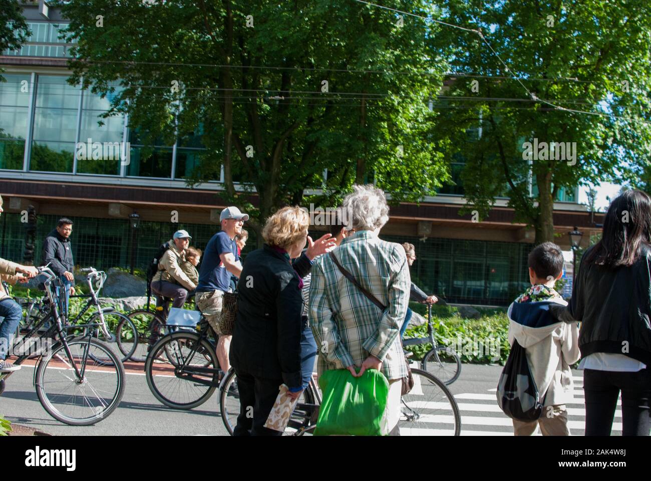 Persone a cavallo bicyle in città in una giornata di sole Foto Stock