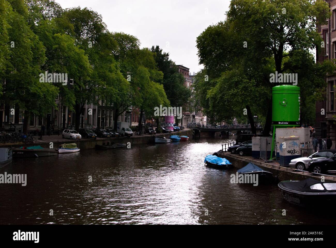 Fiume ad Amsterdam con barche e auto lungo il confine. La giornata è torbida e tranquilla. Foto Stock