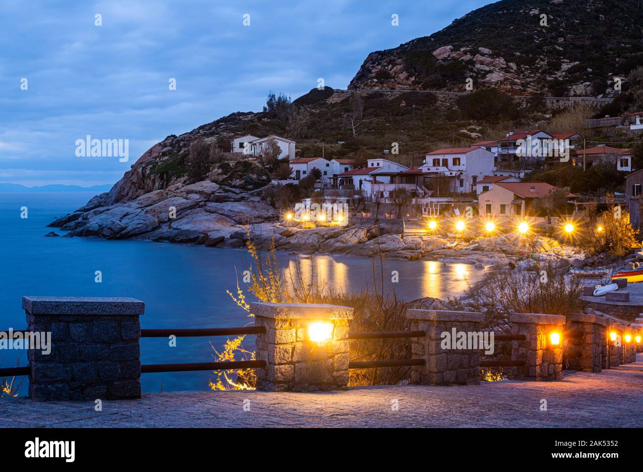 Chiessi, Isola d'Elba, Toscana, Italia. Bellissima vista del villaggio al tramonto. Macchia mediterranea, case e alberghi con le luci gialle il Foto Stock