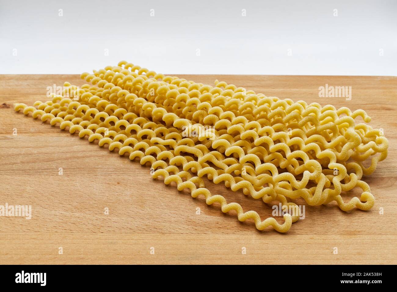 Materie Fusilli lunghi bucati. Tradizionale pasta italiana sul tavolo in legno Foto Stock