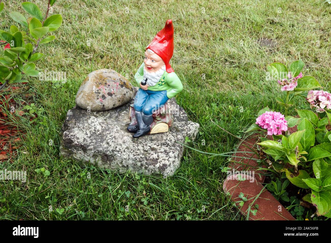 Germania Giardino gnome figura con tappo rosso, prato piccolo giardino Foto Stock