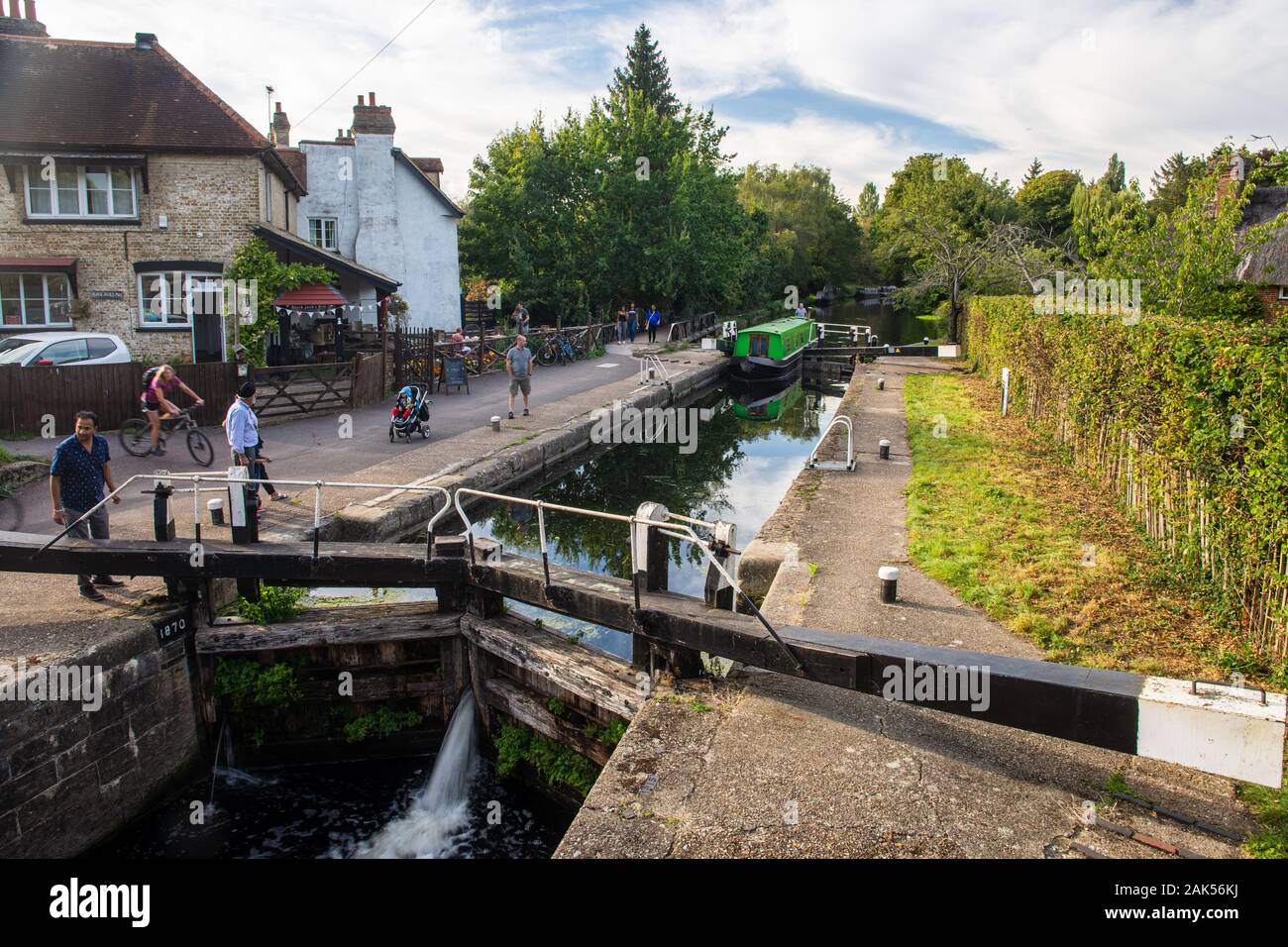London, England, Regno Unito - 14 Settembre 2019: la gente a piedi e in bicicletta lungo il Grand Union Canal alzaia mentre un tradizionale narrowboat naviga Black Jac Foto Stock