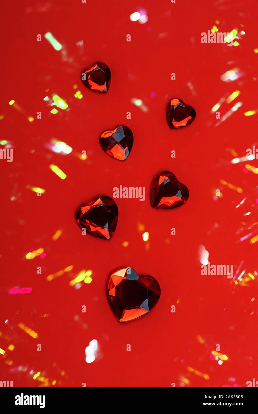 Vetro azzuro cuori sparsi su sfondo rosso, amore felice il giorno di san valentino concetto Foto Stock