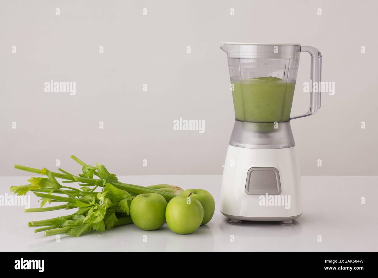 Il sedano e le mele con blender su sfondo bianco, mangiare sano concetto Foto Stock