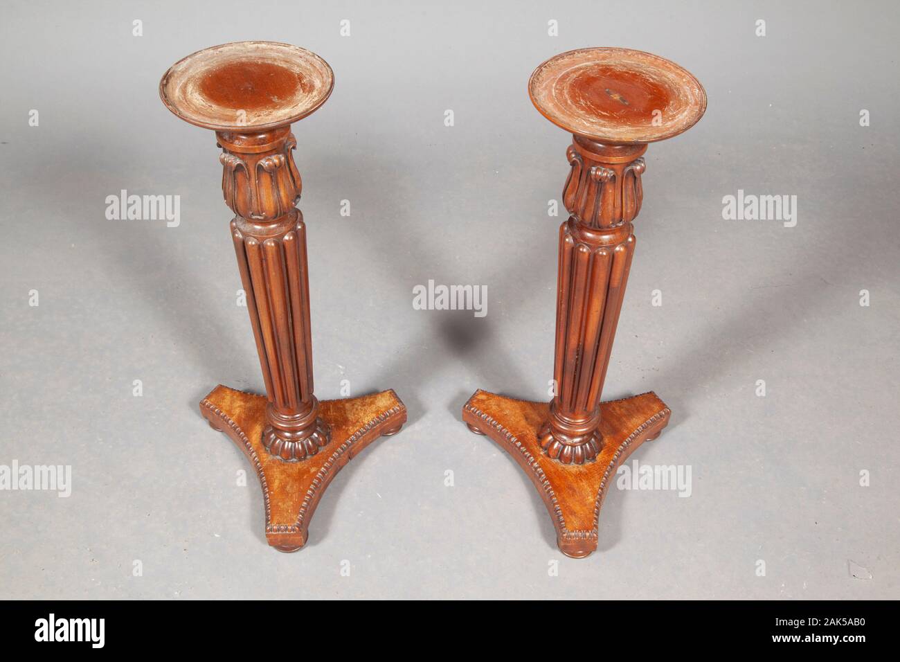 Tavolo in legno marrone lungo le gambe, isolata su uno sfondo grigio con ombre Foto Stock