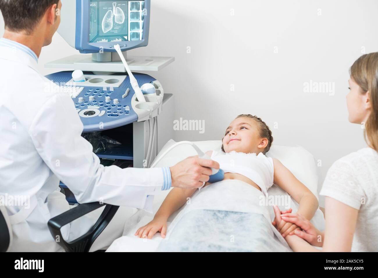 Medico esamina a ultrasuoni poco ventre del paziente Foto Stock