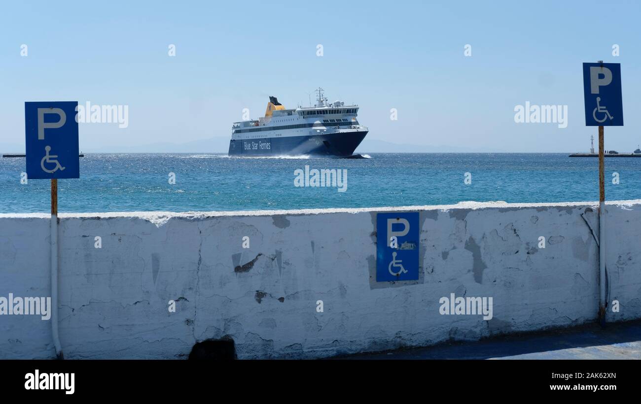 Un blue star ferry vela nel porto di Tinos in Grecia. Foto Stock