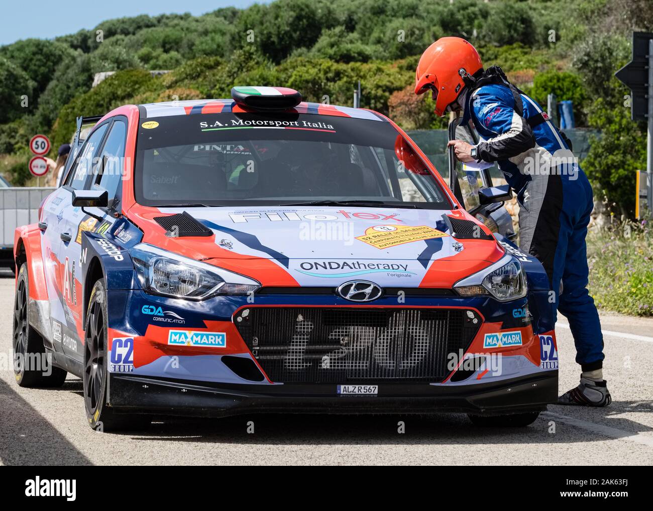 Hyundai i20 sport si arresta prima della prova speciale del Rally del Salento mentre il navigatore parla per il conducente. Foto Stock