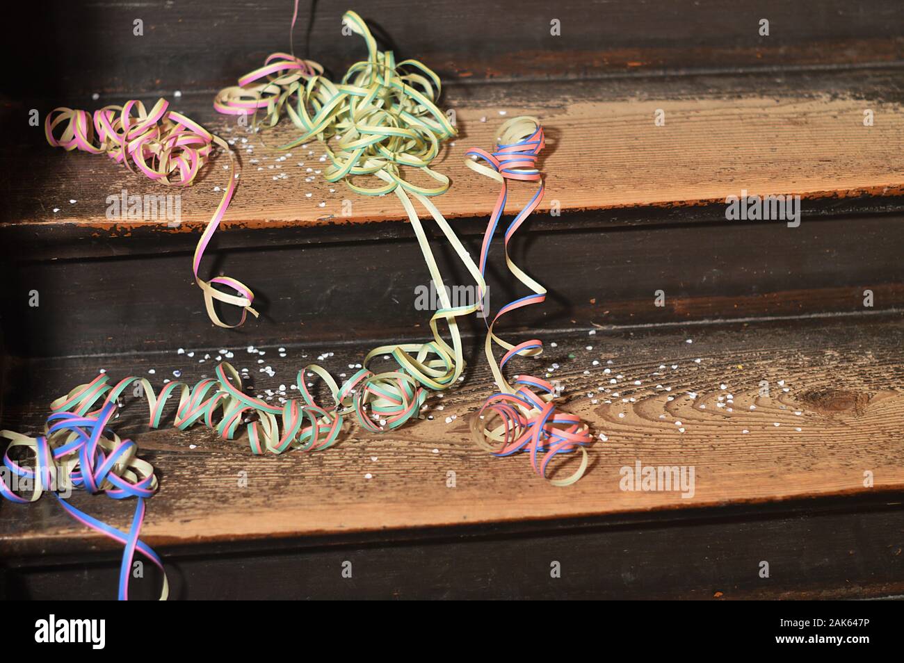 Dopo un party - left overs di coloratissimi coriandoli e nastri di carta su legno passi Foto Stock