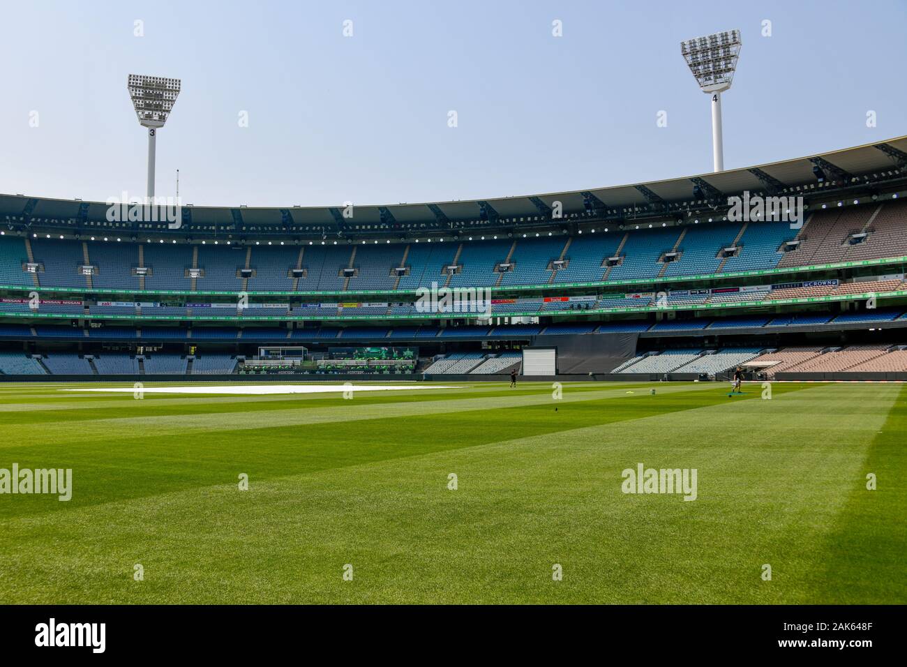 MCG - Melbourne Cricket Ground vista dal santificato tappeto erboso verde con coperchi del passo, posti a sedere e torri di illuminazione in background Foto Stock