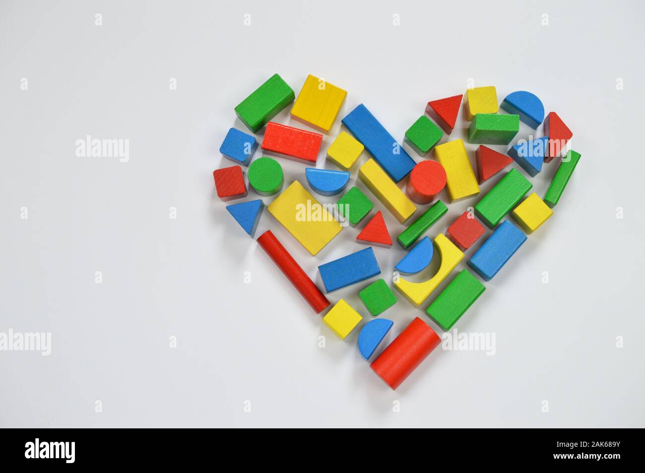In legno colorato blocchi giocattolo sagomatura della forma di un cuore Foto Stock