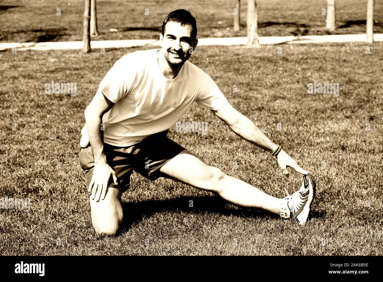 L'uomo presso il parco facendo esercizi di stretching Foto Stock