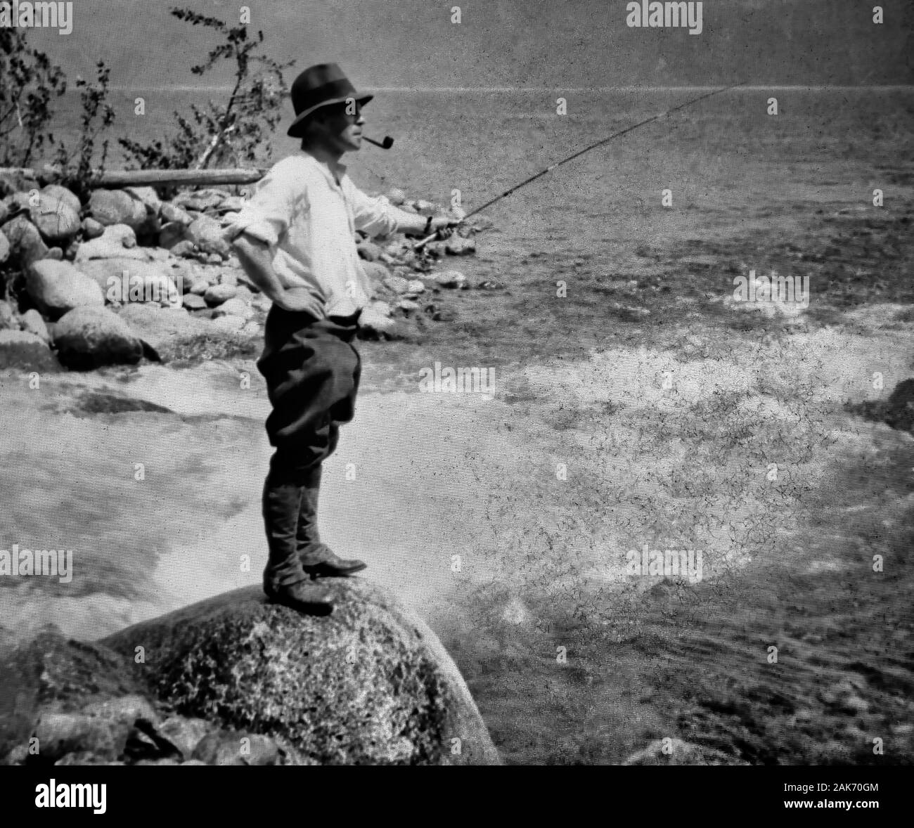 Fotografia di un c 1910 Black & White Magic Lantern slide di vetro su una scatola di luce di un Victorian / Edwardian uomo di Pesca a Mosca Report di Pesca sulle rive di un fiume in Scozia, cappello, tubo asta, soffietti, stivali. Fotografi originale copyright è scaduto. Fotografia digitale copyright Doug Blane. Restauro Digitale & editing copyright Doug Blane. Foto Stock