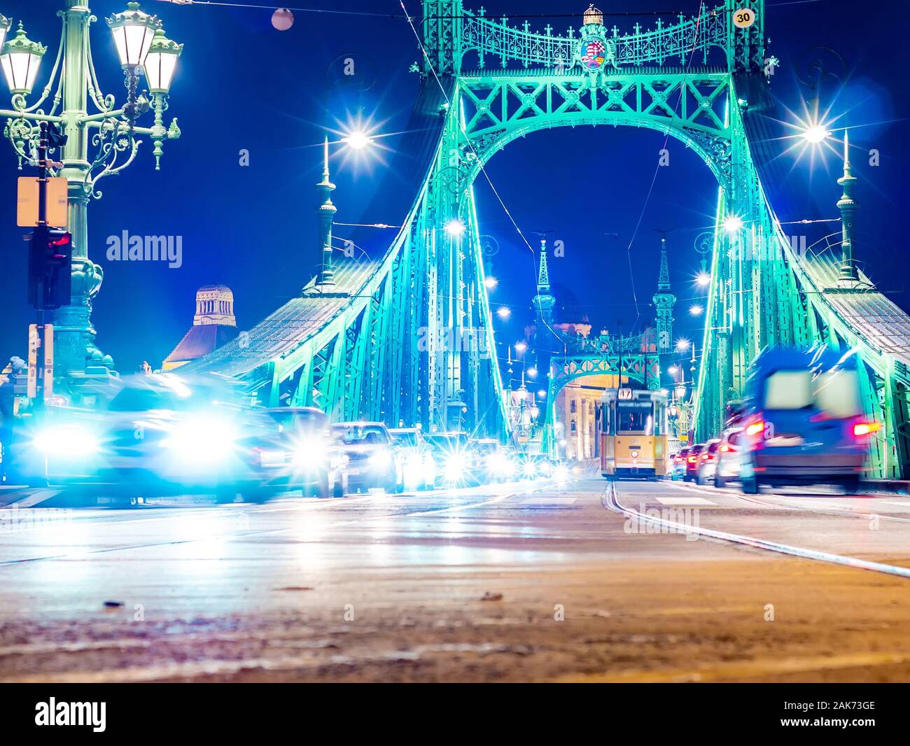 BUDAPEST, Ungheria - 14 dicembre 2019: vista sul traffico sulla piazza Fovam e il Ponte della Libertà di notte a Budapest, Ungheria. Foto Stock