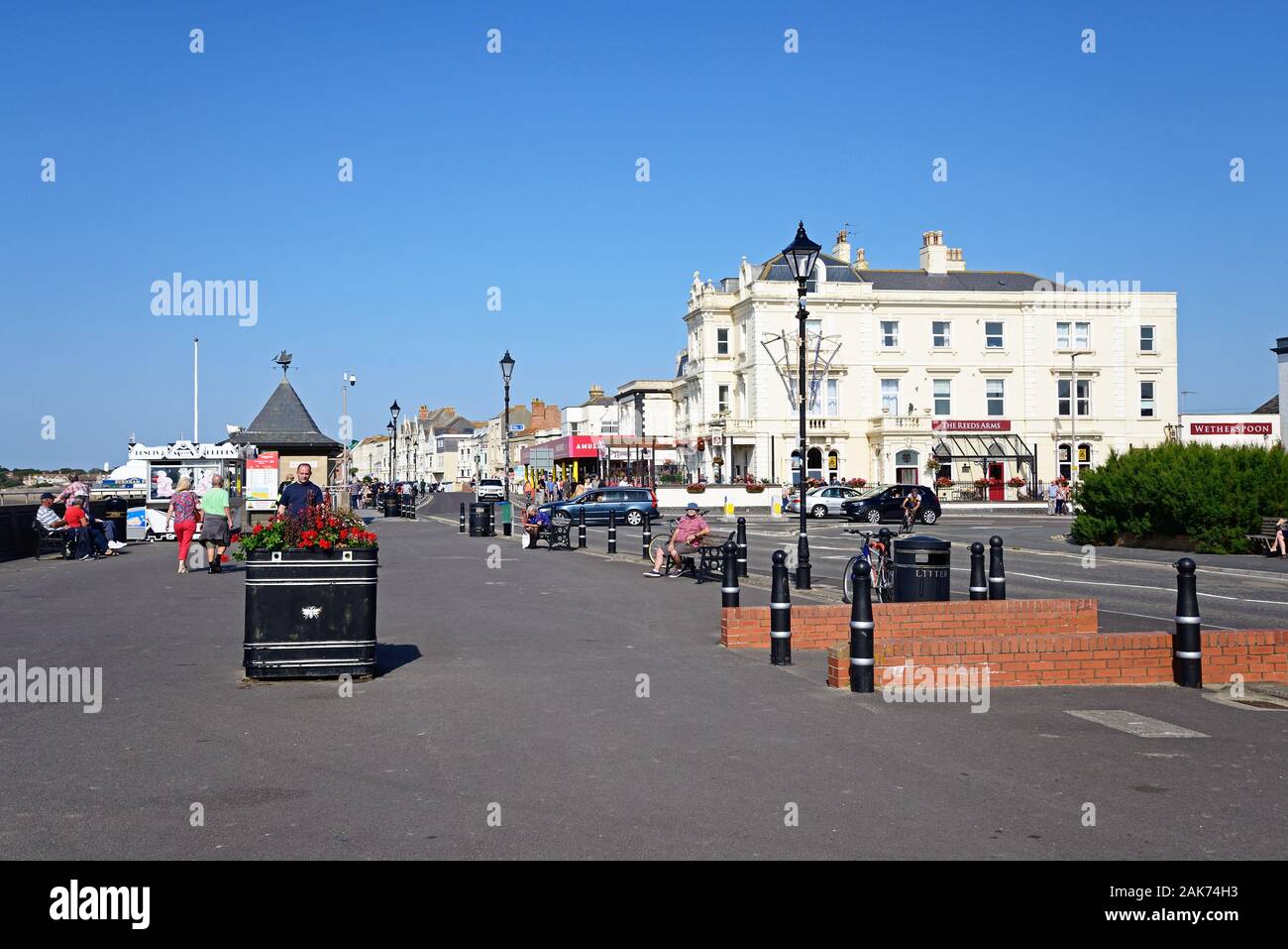 Vista lungo la passeggiata sul lungomare con turisti che si godono la impostazione, Burnham-on-Sea, Inghilterra, Regno Unito. Foto Stock