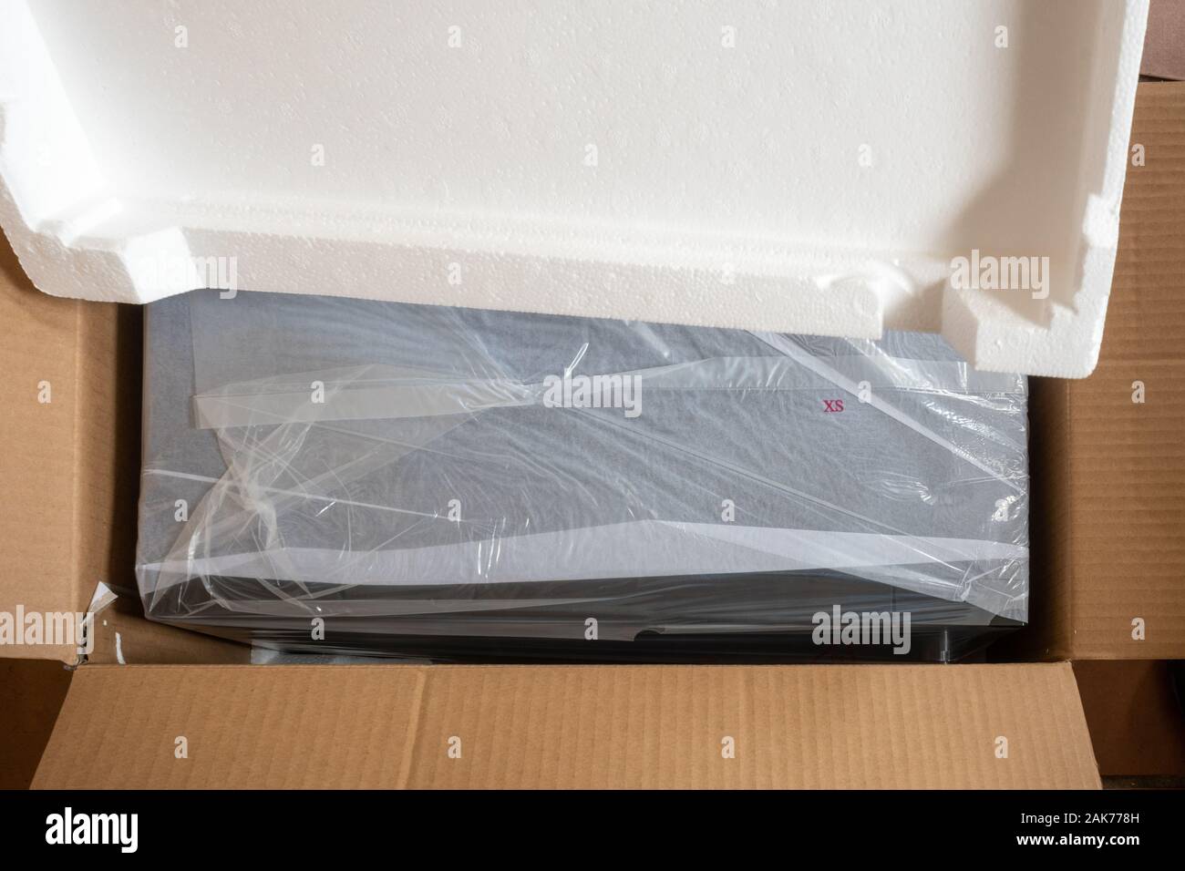 Materiali di imballaggio attorno ad un forno a microonde - aprire la  scatola di cartone con polistirene e sacchetto di plastica avvolgente -  riciclaggio e rifiuti Nozione Foto stock - Alamy