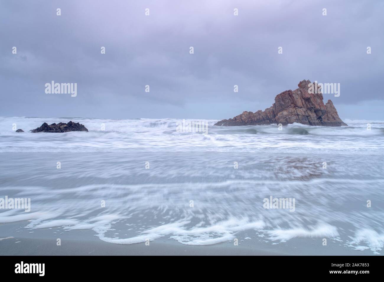 Il mare isolato si innalza tra le onde nebbiose a lunga esposizione sulla costa vulcanica del nord di Tenerife, spagna. Foto Stock