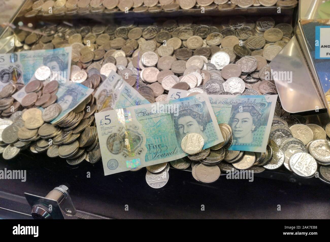 Il denaro è visto in una moneta "spintore" gioco arcade in Swanage Dorset, novembre 2019. Foto Stock