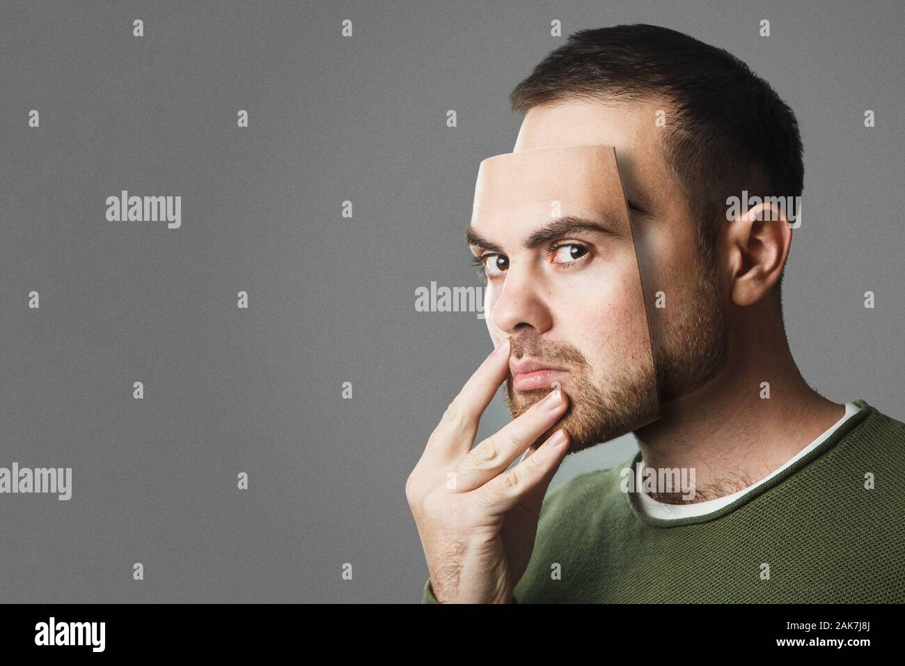 Sii te stesso. Bel uomo detiene una maschera del suo volto. Copia dello spazio. Foto Stock