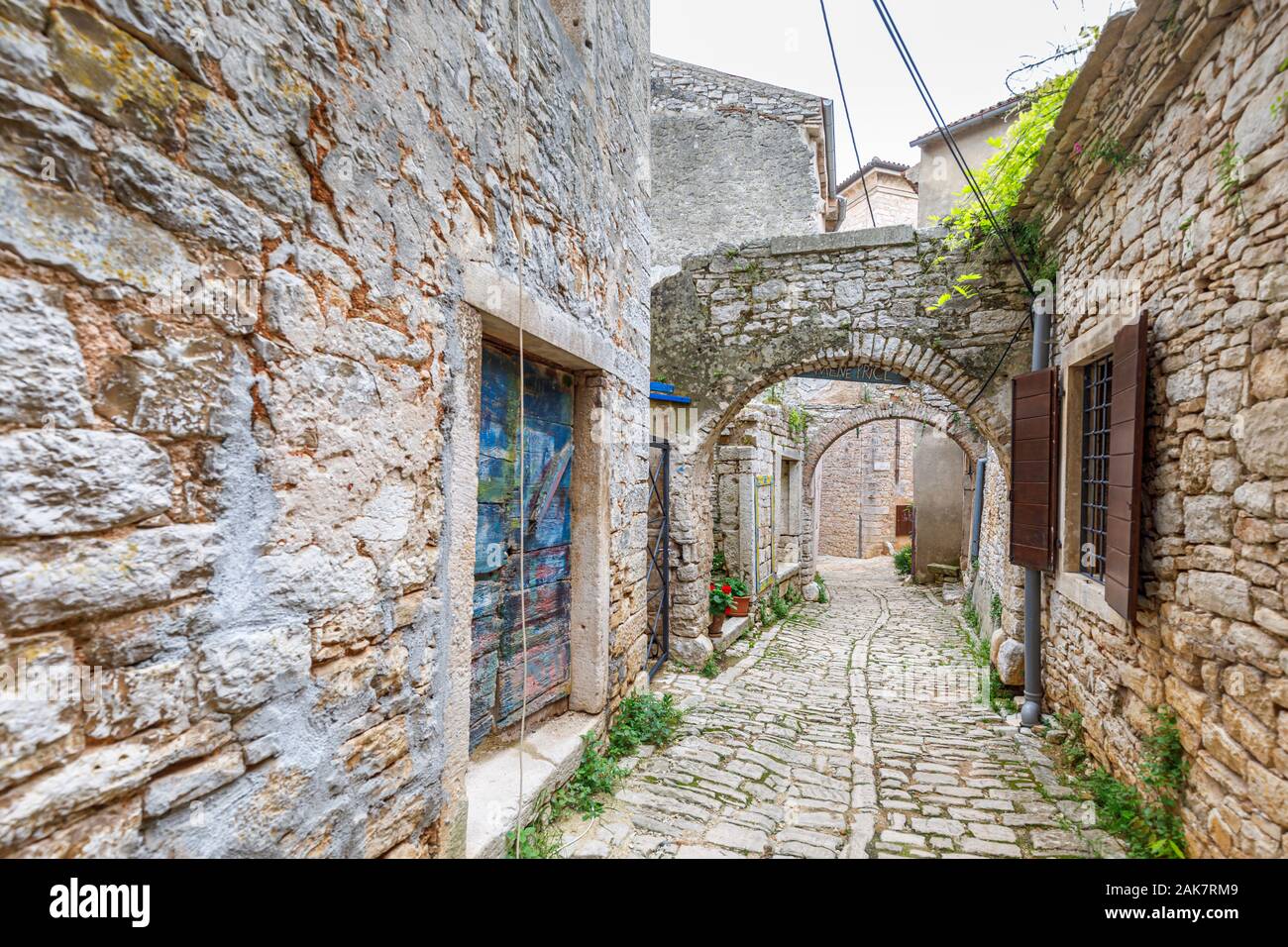 Tipico acciottolato stretto vicoletto con archi di pietra nel centro storico della cittadina nella balla, una piccola cittadina collinare sul Mont Pélerin in Istria, Croazia Foto Stock