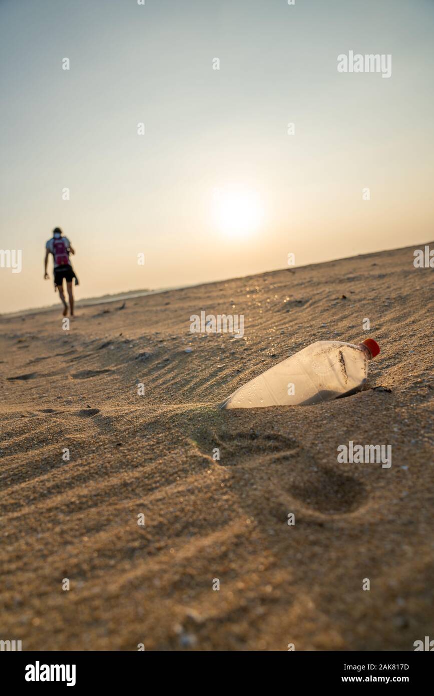 Persona a piedi lontano da rifiuti su una spiaggia Foto Stock