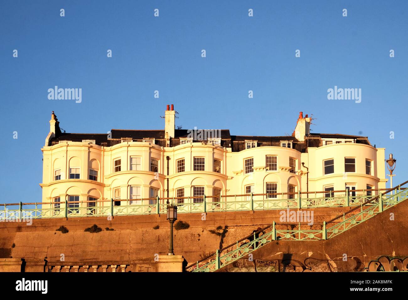 Brighton, Sussex, England, Regno Unito, 12-02-2019 UK, una tipica riga di bianco stile Geogian case a schiera sollevata sul lungomare di Brighton, Foto Stock