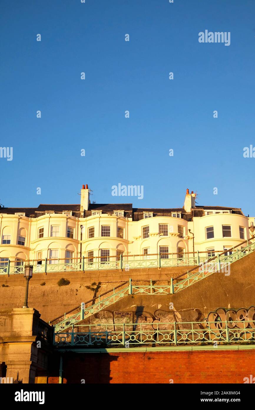 Brighton, Sussex, England, Regno Unito, 12-02-2019 UK, una tipica riga di bianco stile Geogian case a schiera sollevata sul lungomare di Brighton, Foto Stock
