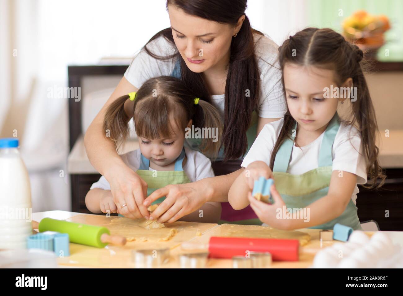 Famiglia bambini e la mamma i biscotti di cottura in cucina insieme Foto Stock