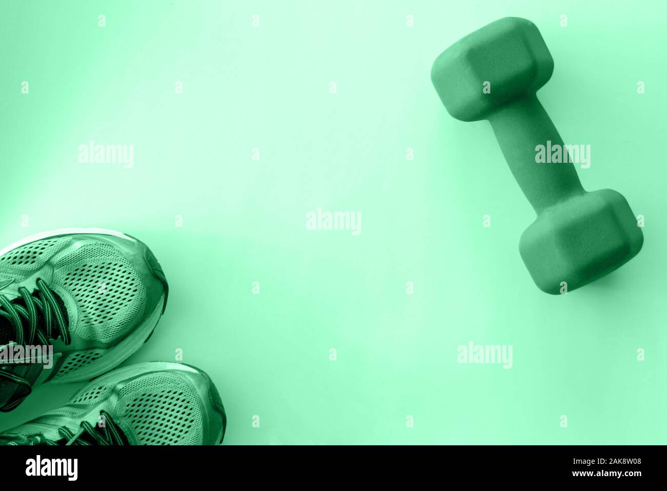Sneakers e un manubrio tonica in colore verde Foto Stock