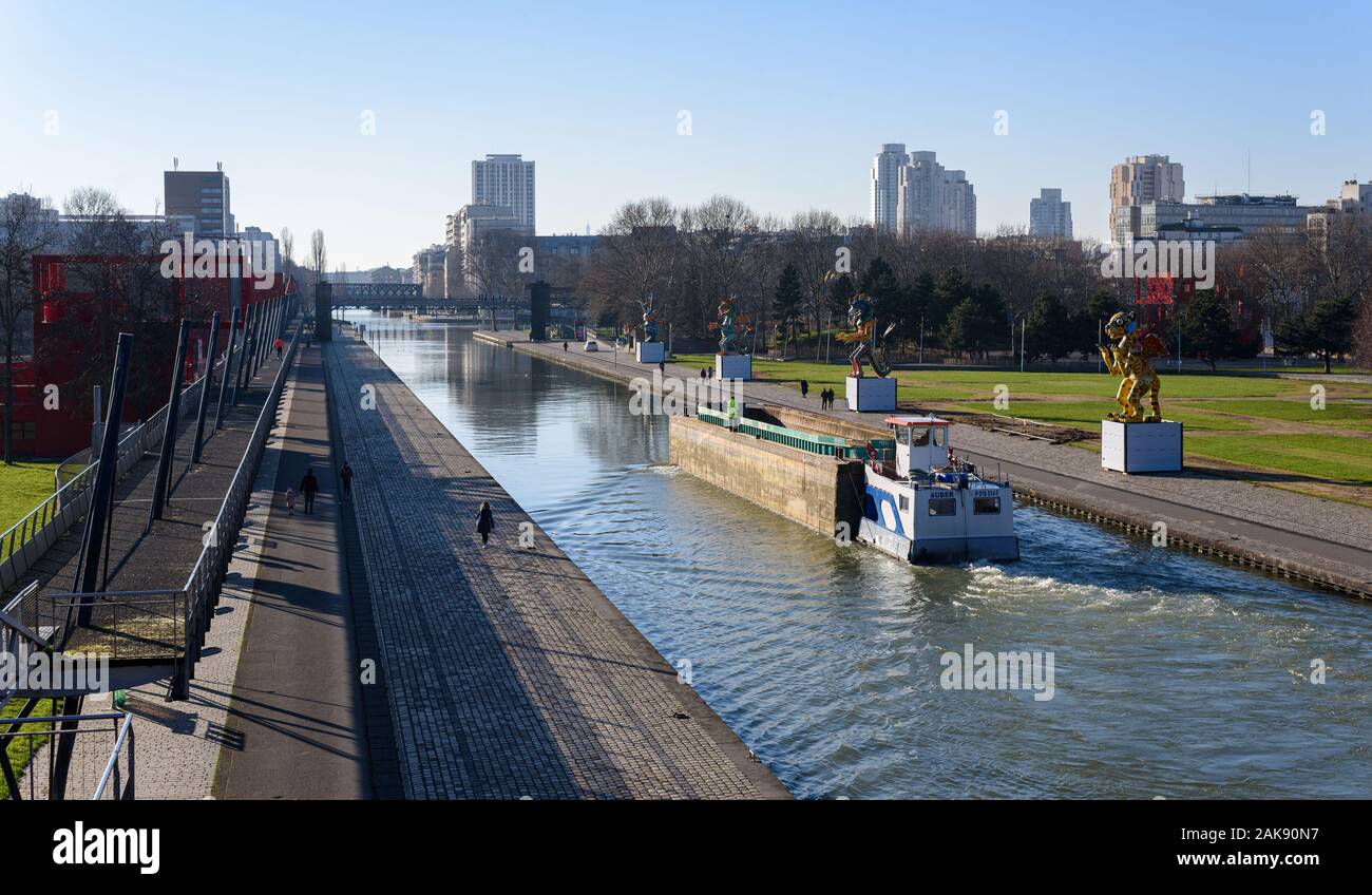 Parigi, Francia - 6 gennaio 2020: una motorizzata in acciaio per via navigabile barge circola sull'Ourcq canal nel Parc de la Villette, in inverno. Foto Stock