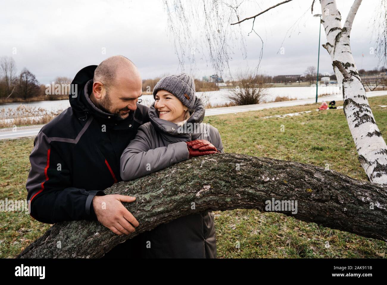 Amare giovane marito e moglie in piedi da una struttura ricurva Foto Stock