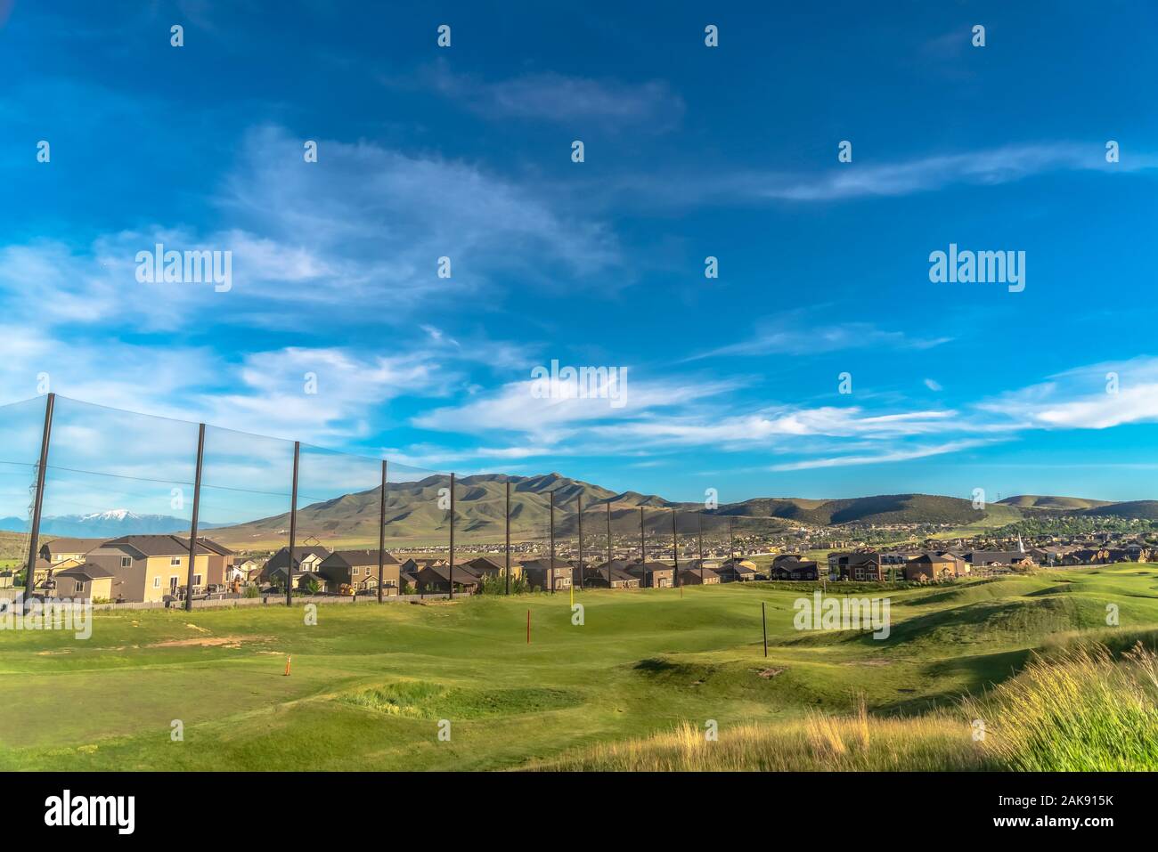 Campo da golf fairway e putting green con flagsticks sotto il cielo blu e nuvole Foto Stock