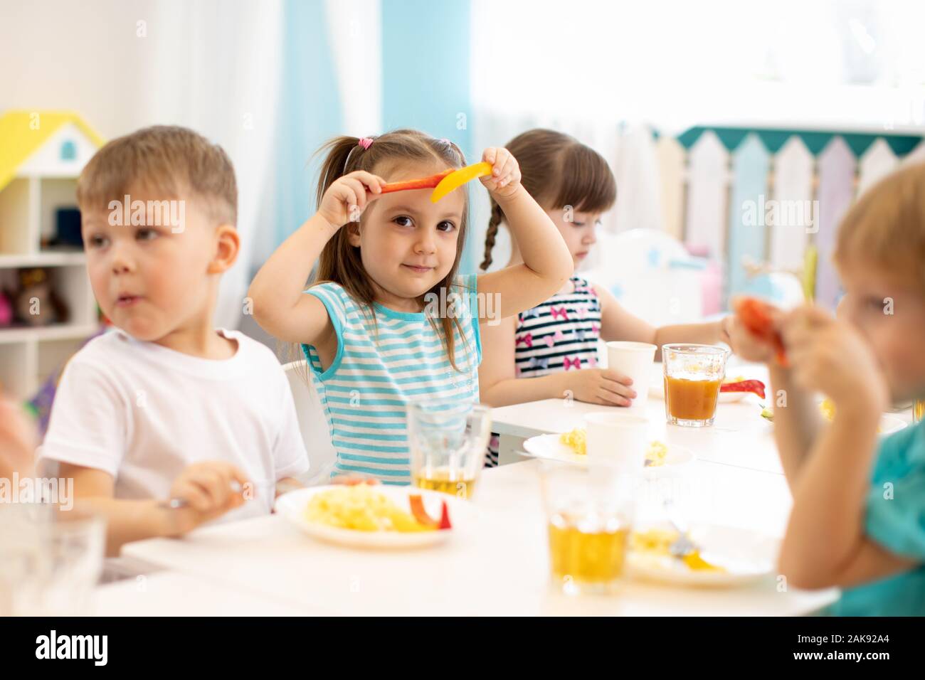 Gruppo di bambini hanno un pranzo al kindergarten Foto Stock
