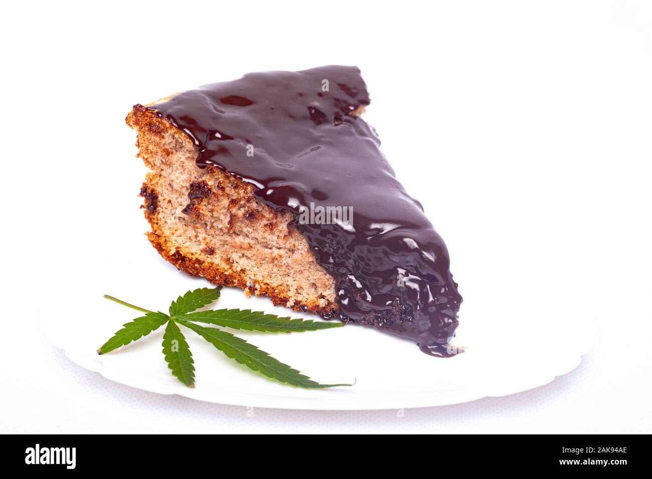 Cioccolata calda pan di spagna con foglie di cannabis su sfondo bianco closeup Foto Stock