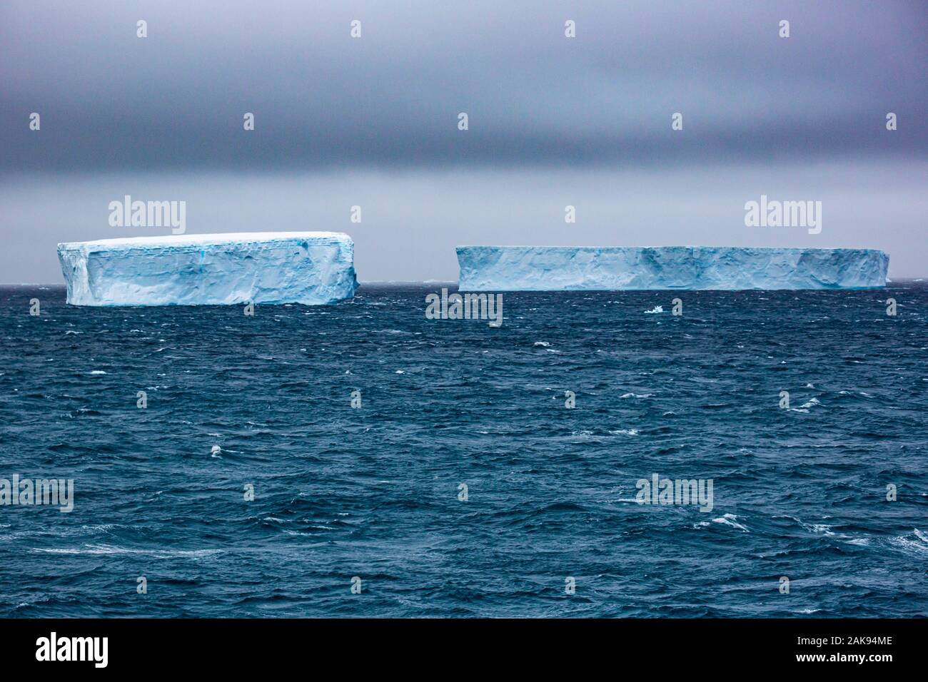 Iceberg di fusione con glaçon in primo piano, galleggianti in mare, Antartide Foto Stock