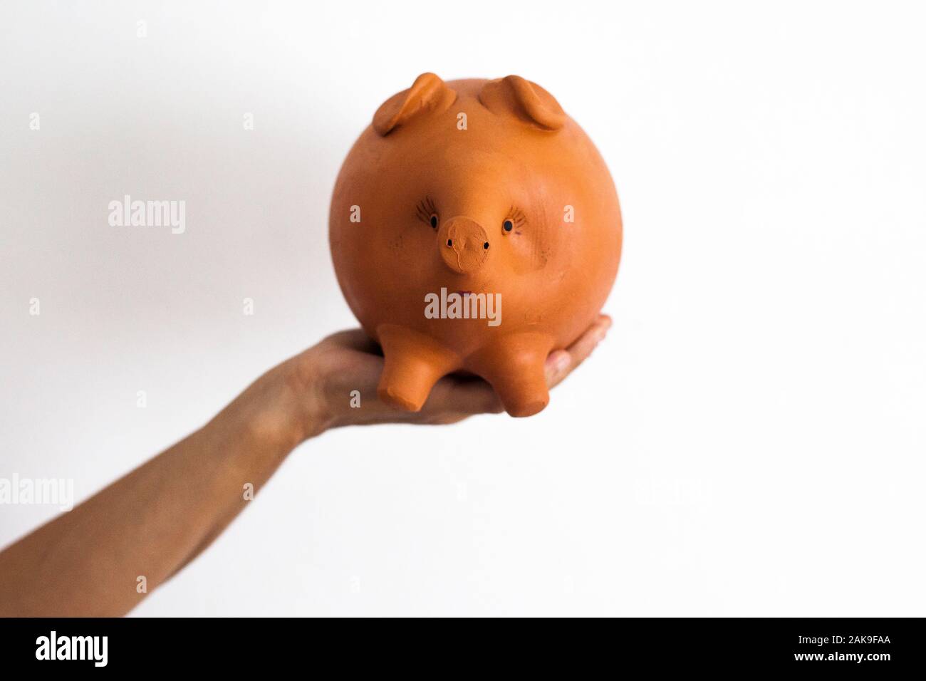 Mano che tiene un Maialino salvadanaio Foto Stock