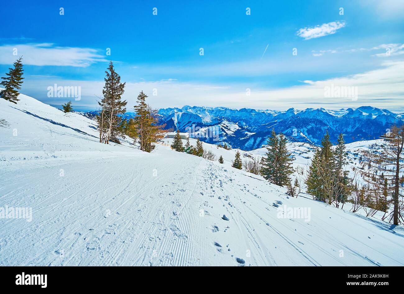 Il paesaggio di montagna con ampia corduroy curate piste, allungandosi lungo il pendio della montagna Feuerkogel altopiano, Ebensee, Salzkammergut, Austr Foto Stock