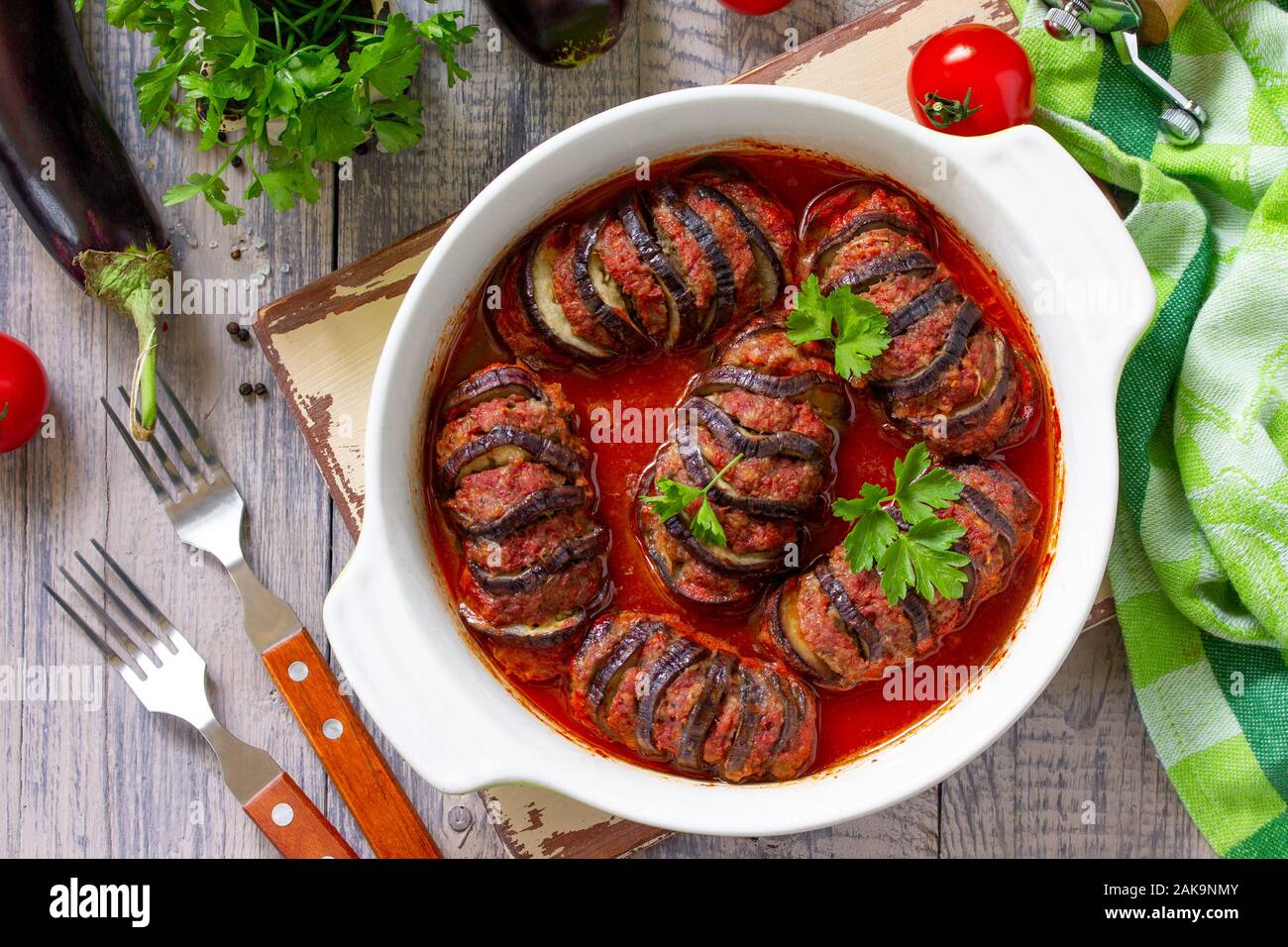 La Giornata del ringraziamento di cibo. In casa cotto le melanzane farcite con carne di tacchino in salsa di pomodoro su un tavolo di legno. Vista dall'alto su uno sfondo piatto. Foto Stock
