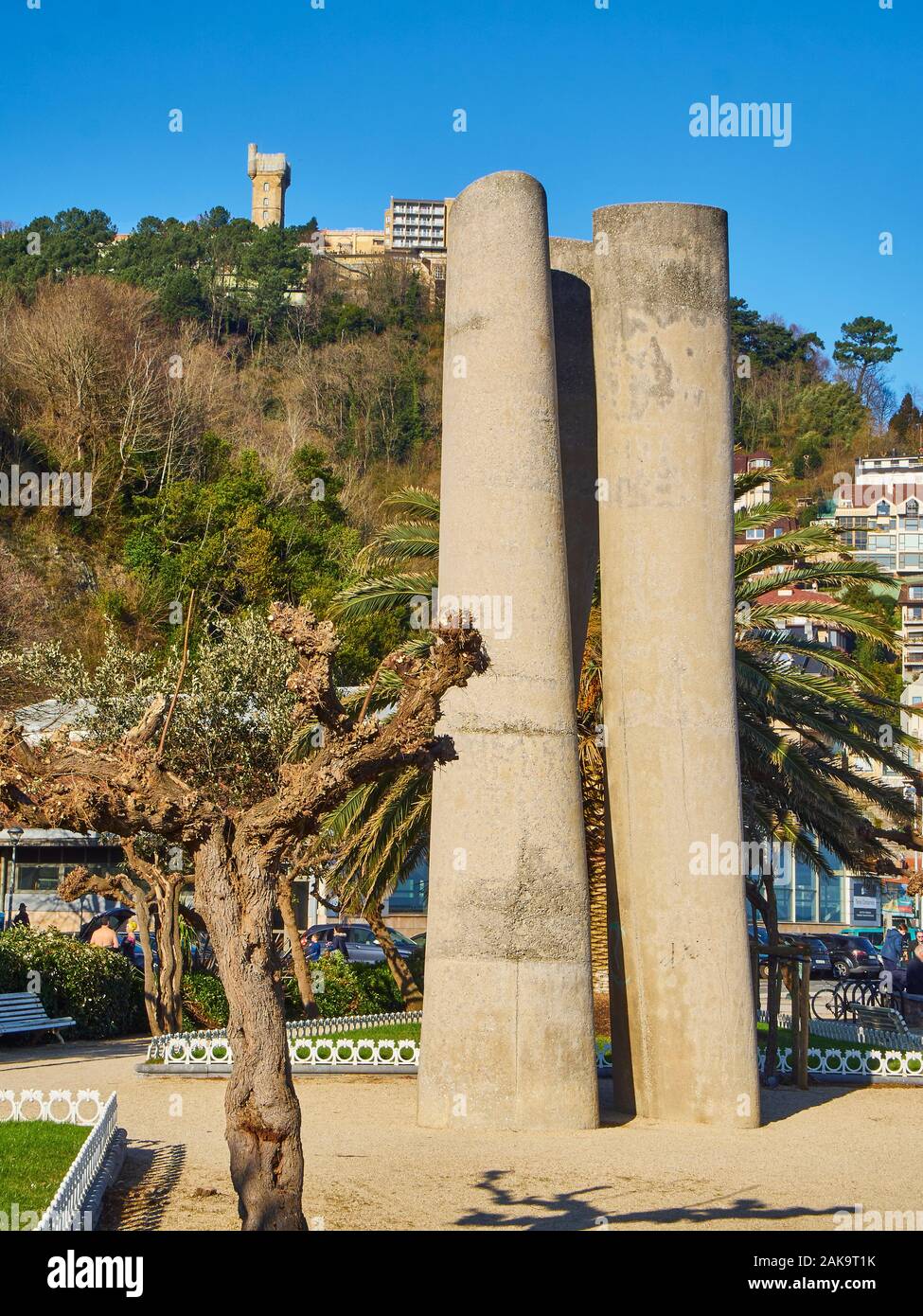 La statua di Zeharki di Jose Ramon Anda con la torre Igueldo sullo sfondo, al giorno di sole. San Sebastian, Paesi Baschi, Guipuzcoa. Spagna. Foto Stock