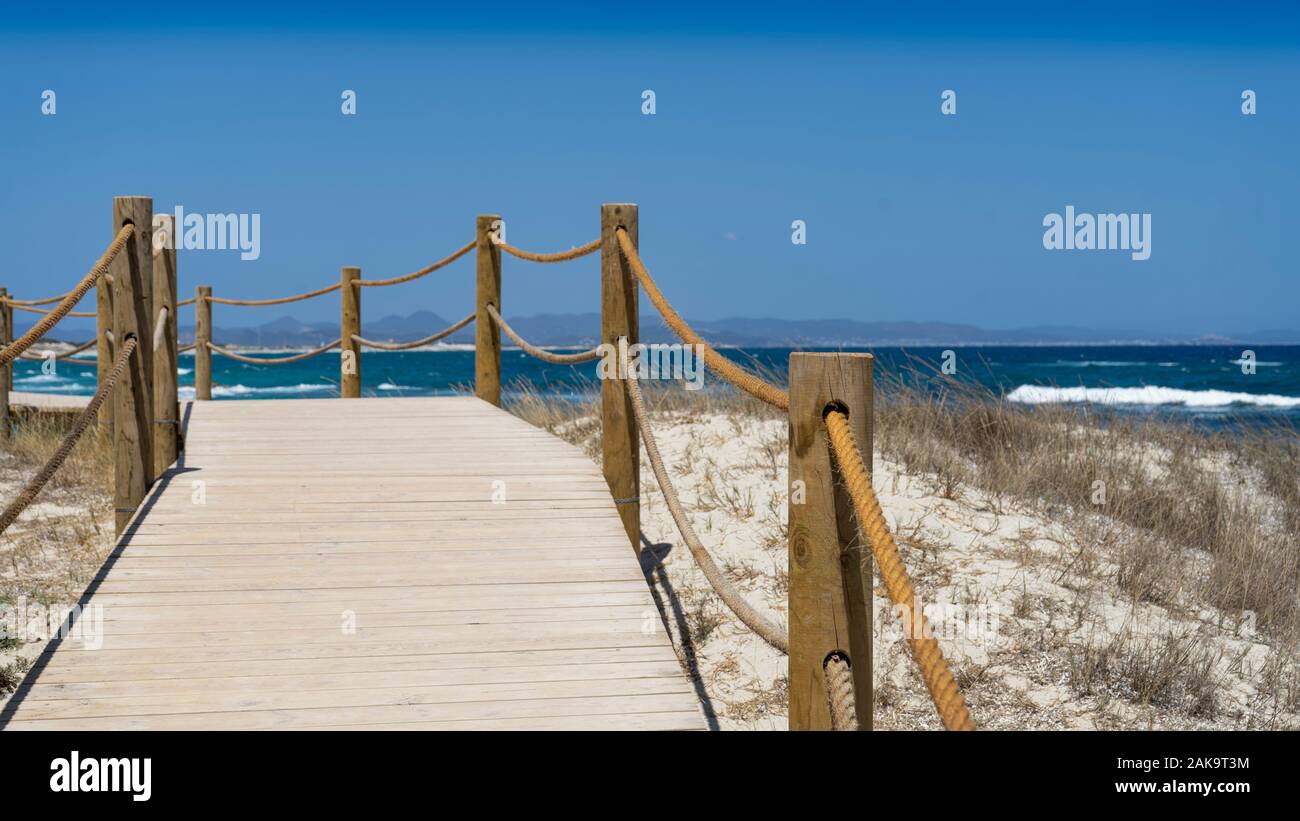 In legno percorso a piedi lungo la spiaggia, l'isola di Formentera. Spagna. Passerella in legno nell'isola di Formentera. Foto Stock