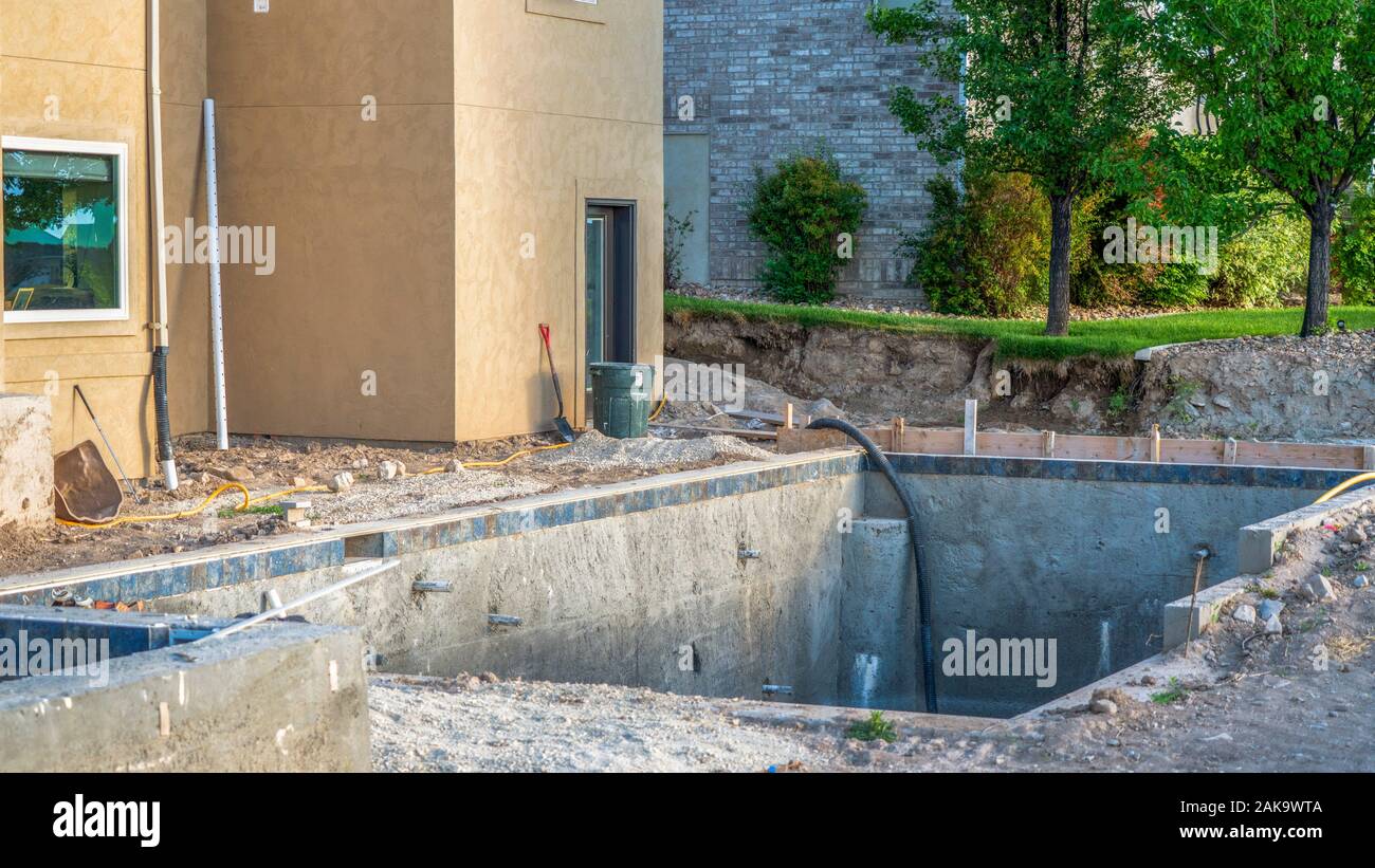 Pano la costruzione di un complesso residenziale piscina con case e alberi sullo sfondo Foto Stock