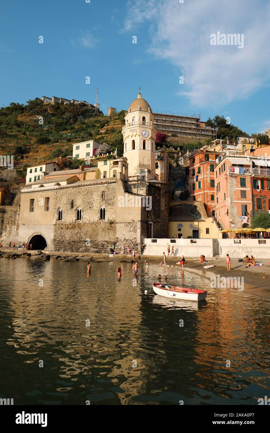 Estate turisti che si godono la piccola spiaggia di Porto e colorata architettura di Vernazza, il Parco Nazionale delle Cinque Terre Liguria Italia EU Foto Stock