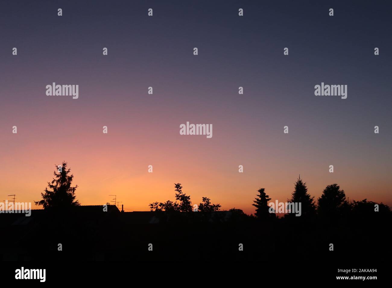 cielo arancione e viola splendidamente colorato sopra il villaggio Foto Stock