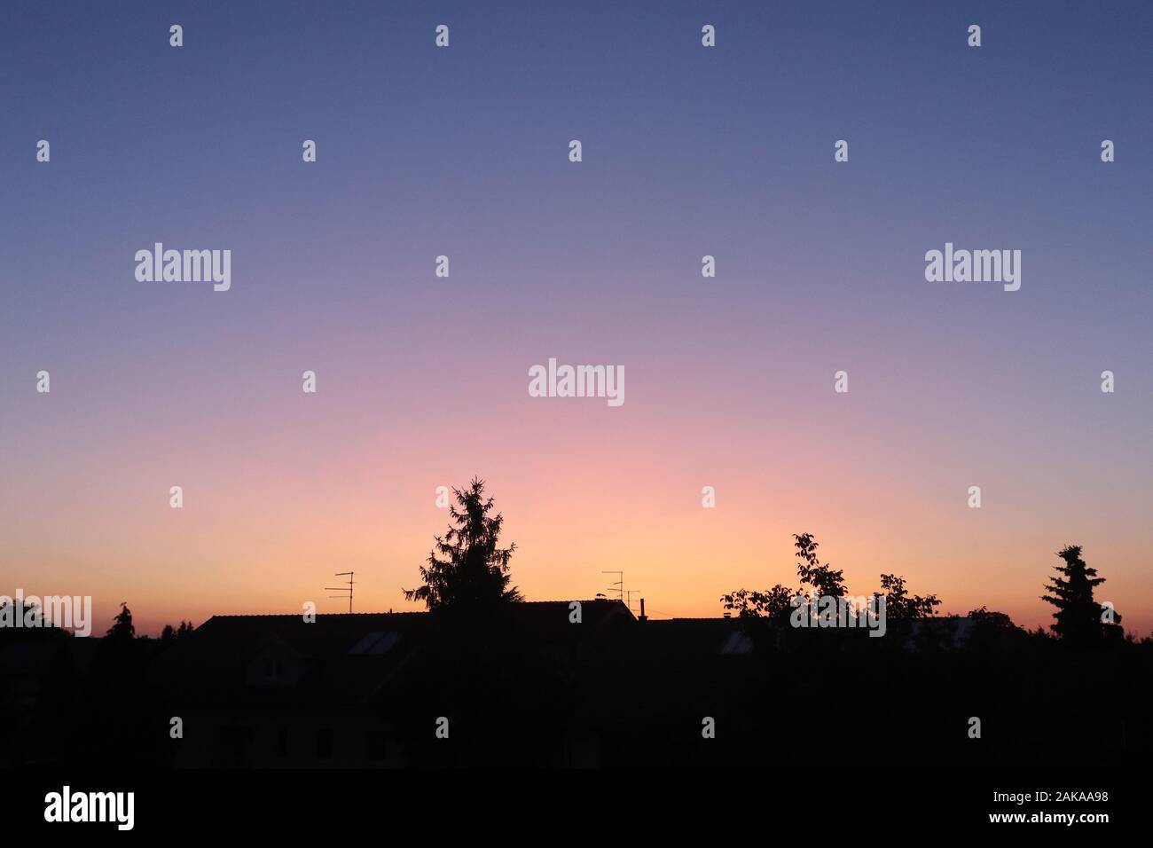 cielo arancione e viola splendidamente colorato sopra il villaggio Foto Stock