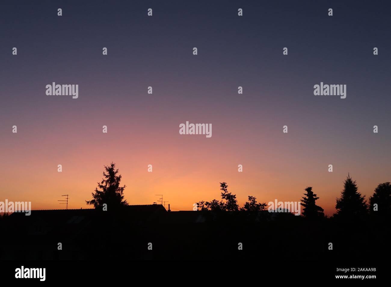 cielo arancione e viola splendidamente colorato sopra il villaggio Foto Stock